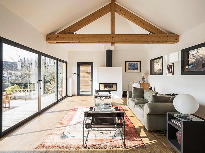 Maison bois et piscine. Le grand salon et la cheminée